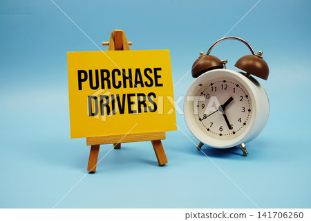 Purchase Drivers text written on paper card and alarm clock on blue background Purchase Drivers text written on paper card and alarm clock on blue background 141706260