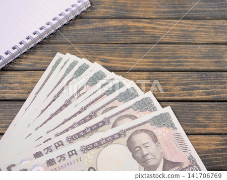 Copy space for a 10,000 yen bill and a wood grain background. Copy space for a 10,000 yen bill and a wood grain background. 141706769