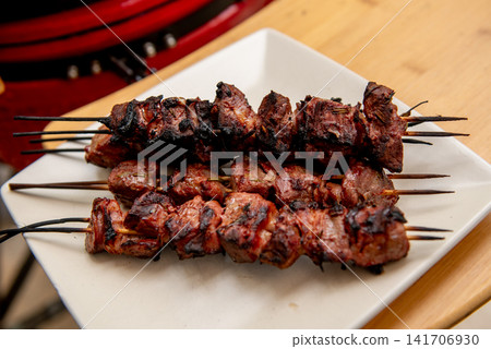 close up of grilled shashlik skewers over glowing charcoal fire close up of grilled shashlik skewers over glowing charcoal fire 141706930
