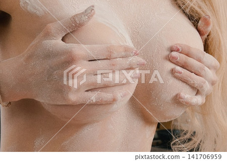 Woman's Hands Covering Chest Covered in White Powder 141706959