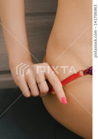 Woman's Hand with Pink Manicure Adjusting Red Lingerie Strap Woman's Hand with Pink Manicure Adjusting Red Lingerie Strap 141706963