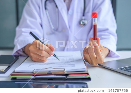 Medical worker checking biochemistry blood screening report on desk. Medical worker checking biochemistry blood screening report on desk. 141707766
