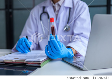 Doctor analyzing blood test results report in clinic office. Healthcare diagnostics and pathology laboratory test results concept. Doctor analyzing blood test results report in clinic office. Healthcare diagnostics and pathology laboratory test results concept. 141707812