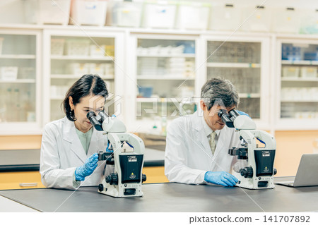 Researchers who conduct research using microscopes in the laboratory Researchers who conduct research using microscopes in the laboratory 141707892