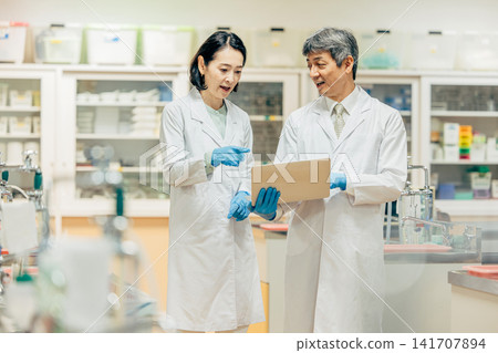 在實驗室中使用顯微鏡進行研究的研究人員 在實驗室中使用顯微鏡進行研究的研究人員 141707894