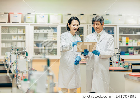 在實驗室中使用顯微鏡進行研究的研究人員 在實驗室中使用顯微鏡進行研究的研究人員 141707895