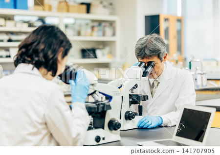 Researchers who conduct research using microscopes in the laboratory Researchers who conduct research using microscopes in the laboratory 141707905