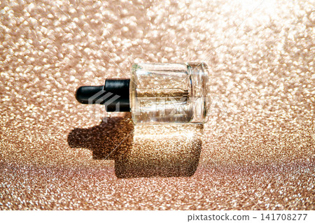 Glowing serum bottle on shimmering rose gold background Glowing serum bottle on shimmering rose gold background 141708277