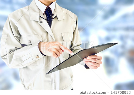 A male worker examines documents and thinks on-site. A male worker examines documents and thinks on-site. 141708933