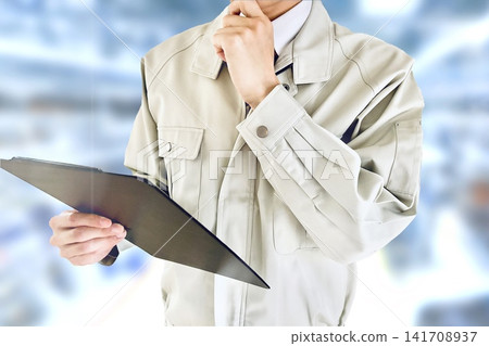 一名男工人在現場查看文件並思考。 一名男工人在現場查看文件並思考。 141708937