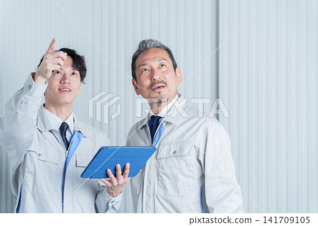 A worker conducting an on-site survey using a tablet. A worker conducting an on-site survey using a tablet. 141709105