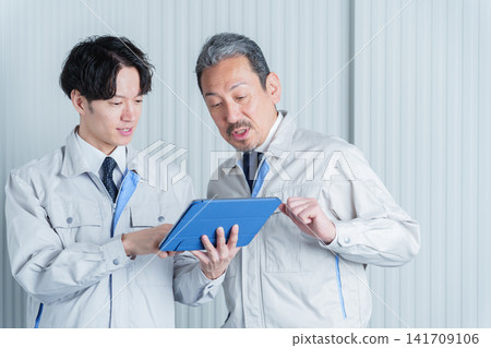 一名工作人員正在使用平板電腦進行現場勘測。 一名工作人員正在使用平板電腦進行現場勘測。 141709106