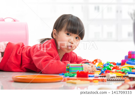 Cute Asian Child Girl Playing with Colorful Plastic Building Blocks on Floor, Creative Educational Toys for Early Development, Toddler Having Fun at Home Cute Asian Child Girl Playing with Colorful Plastic Building Blocks on Floor, Creative Educational Toys for Early Development, Toddler Having Fun at Home 141709333