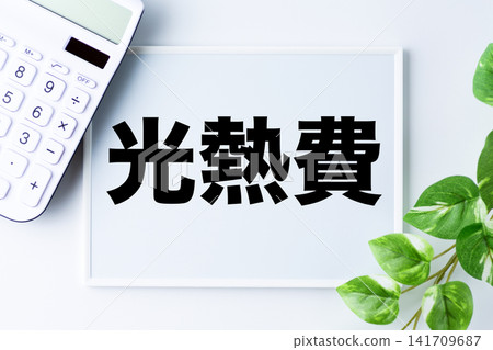 A whiteboard with the words "utility costs" and a white calculator. A whiteboard with the words "utility costs" and a white calculator. 141709687