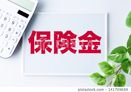 一塊寫著「保險賠償」字樣的白板和一台白色計算器 一塊寫著「保險賠償」字樣的白板和一台白色計算器 141709689