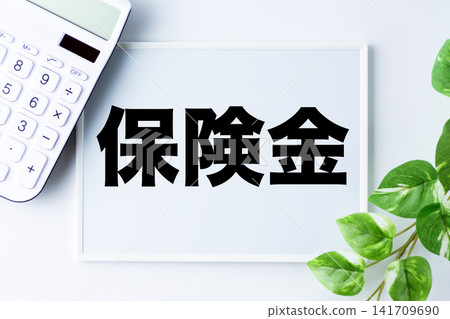 一塊寫著「保險賠償」字樣的白板和一台白色計算器 141709690