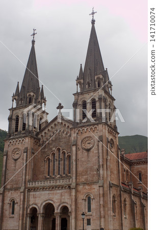 Close-up view of the facade of Santa Maria la Real de Covadonga basilica in a cloudy day. Close-up view of the facade of Santa Maria la Real de Covadonga basilica in a cloudy day. 141710074