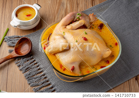 simmered whole chicken soup with traditional herbs and dates simmered whole chicken soup with traditional herbs and dates 141710733