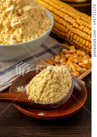 fine yellow corn flour heap with dried corn cob in background fine yellow corn flour heap with dried corn cob in background 141711178
