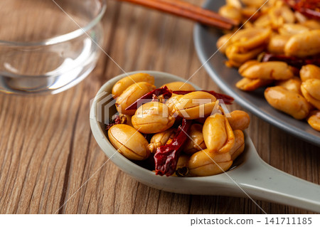 spicy roasted peanuts with chili peppers packed in sealed container spicy roasted peanuts with chili peppers packed in sealed container 141711185
