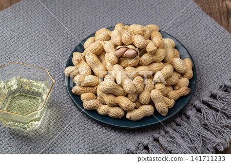 roasted peanuts in shell served on blue dish roasted peanuts in shell served on blue dish 141711233