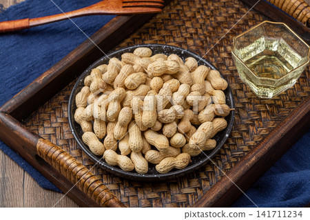 roasted peanuts in shell served on blue dish roasted peanuts in shell served on blue dish 141711234