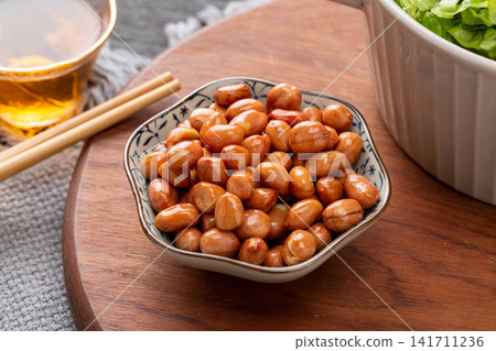 fried yellow peanuts served in small ceramic bowl 141711236
