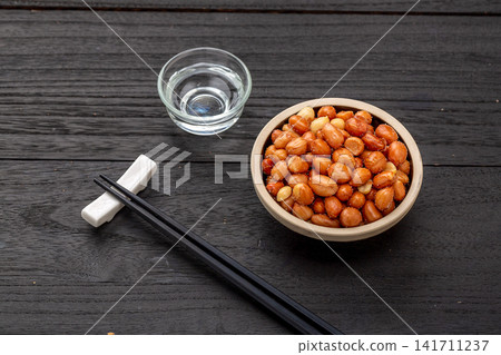 fried yellow peanuts served in small ceramic bowl 141711237