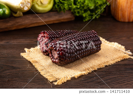 raw black waxy corn cobs isolated on white background 141711410