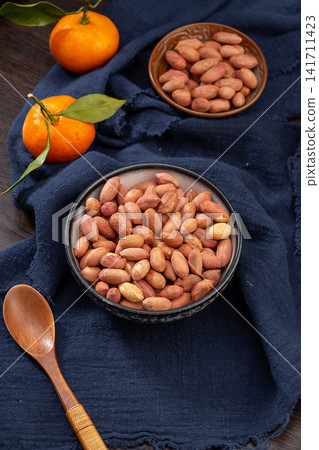 thirteen spice peanuts served in a bowl on a wooden tray thirteen spice peanuts served in a bowl on a wooden tray 141711423