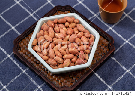 thirteen spice peanuts served in a bowl on a wooden tray thirteen spice peanuts served in a bowl on a wooden tray 141711424