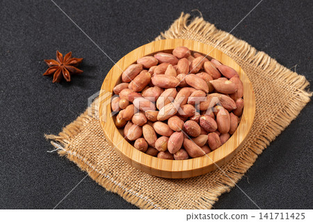 thirteen spice peanuts served in a bowl on a wooden tray thirteen spice peanuts served in a bowl on a wooden tray 141711425