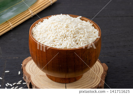 raw white glutinous sticky rice with wrapped bamboo rice dumplings raw white glutinous sticky rice with wrapped bamboo rice dumplings 141711625