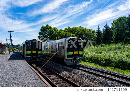 在一個晴朗的早晨，JR富良野線的普通列車在禦毛獸站內交錯而過。 141711809