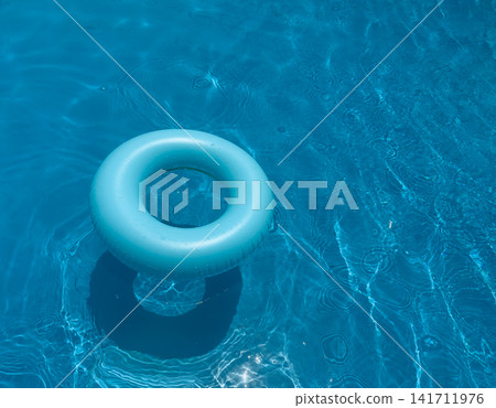Floating ring in clear blue swimming pool during sunny day Floating ring in clear blue swimming pool during sunny day 141711976