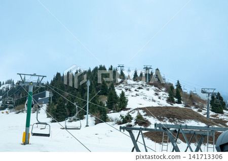 Ski resort chairlifts stand empty against snowy landscape Ski resort chairlifts stand empty against snowy landscape 141713306