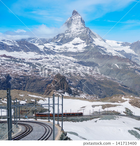 Iconic Matterhorn Mountain with Gornergrat Railway Train in Zermatt, Switzerland, Snow Capped Alpine Peak under Blue Sky, Famous Swiss Alps Landmark landscape and popular European Travel Destination Iconic Matterhorn Mountain with Gornergrat Railway Train in Zermatt, Switzerland, Snow Capped Alpine Peak under Blue Sky, Famous Swiss Alps Landmark landscape and popular European Travel Destination 141713400