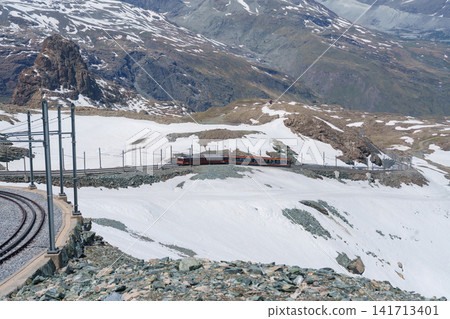 Iconic Matterhorn Mountain with Gornergrat Railway Train in Zermatt, Switzerland, Snow Capped Alpine Peak under Blue Sky, Famous Swiss Alps Landmark landscape and popular European Travel Destination Iconic Matterhorn Mountain with Gornergrat Railway Train in Zermatt, Switzerland, Snow Capped Alpine Peak under Blue Sky, Famous Swiss Alps Landmark landscape and popular European Travel Destination 141713401