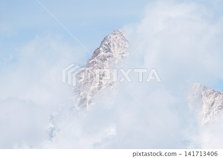 Snow Capped Matterhorn Peak Emerging through Clouds in Zermatt, Switzerland, Dramatic Alpine Mountain Landscape in the Swiss Alps, Landmark and famous European Travel Destination Snow Capped Matterhorn Peak Emerging through Clouds in Zermatt, Switzerland, Dramatic Alpine Mountain Landscape in the Swiss Alps, Landmark and famous European Travel Destination 141713406