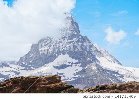Scenic Hiking Trail with Iconic Matterhorn Mountain in Zermatt, Switzerland, Beautiful Swiss Alps Landscape under Blue Sky and White Clouds, Famous Landmark and popular European Travel Destination Scenic Hiking Trail with Iconic Matterhorn Mountain in Zermatt, Switzerland, Beautiful Swiss Alps Landscape under Blue Sky and White Clouds, Famous Landmark and popular European Travel Destination 141713409
