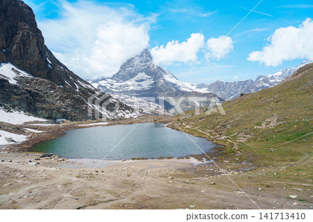 Iconic Reflection of Matterhorn Mountain in Riffelsee Lake, Zermatt, Switzerland, Snow Capped Swiss Alps under Blue Sky, Famous Landmark landscape and popular European Travel Destination Iconic Reflection of Matterhorn Mountain in Riffelsee Lake, Zermatt, Switzerland, Snow Capped Swiss Alps under Blue Sky, Famous Landmark landscape and popular European Travel Destination 141713410