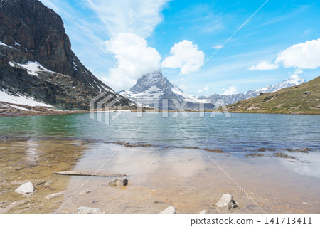 Iconic Reflection of Matterhorn Mountain in Riffelsee Lake, Zermatt, Switzerland, Snow Capped Swiss Alps under Blue Sky, Famous Landmark landscape and popular European Travel Destination Iconic Reflection of Matterhorn Mountain in Riffelsee Lake, Zermatt, Switzerland, Snow Capped Swiss Alps under Blue Sky, Famous Landmark landscape and popular European Travel Destination 141713411