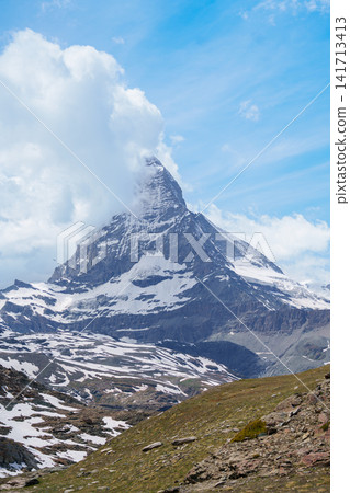 Scenic Hiking Trail with Iconic Matterhorn Mountain in Zermatt, Switzerland, Beautiful Swiss Alps Landscape under Blue Sky and White Clouds, Famous Landmark and popular European Travel Destination Scenic Hiking Trail with Iconic Matterhorn Mountain in Zermatt, Switzerland, Beautiful Swiss Alps Landscape under Blue Sky and White Clouds, Famous Landmark and popular European Travel Destination 141713413