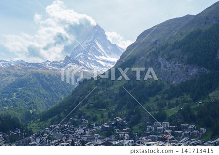 Scenic View of Zermatt Village with Iconic Matterhorn Mountain, Switzerland, Traditional Alpine Town and Snow Capped Swiss Alps under Blue Sky, Famous Landmark and popular Europe Travel Destination Scenic View of Zermatt Village with Iconic Matterhorn Mountain, Switzerland, Traditional Alpine Town and Snow Capped Swiss Alps under Blue Sky, Famous Landmark and popular Europe Travel Destination 141713415