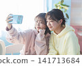 Two young women taking selfies with their smartphones. 141713684