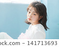 A young woman with a wet-look bob haircut gazes with an enigmatic expression. 141713693