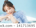 A young woman smiling, wearing a light blue dress. 141713695