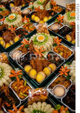 Multiple Indonesian meal boxes featuring nasi daun jeruk rice, eggs, vegetables, and traditional dishes. Ideal for catering, delivery, and Asian food concepts. 141713713