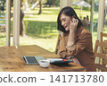 Happy asian woman video call web conference sitting on cozy sofa in living room at home. Smile Female asian people use laptop notebook computer headphones online call working from home watching video 141713780