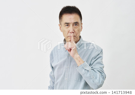 A man making a secret gesture on a white background A man making a secret gesture on a white background 141713948